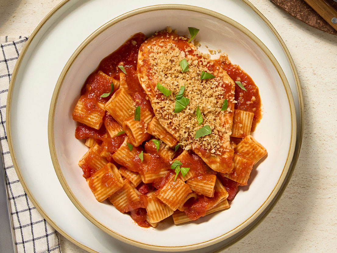 An image of prepared Easy Margherita Chicken made with panko, Parmesan cheese, chicken, Prego® Margherita Sauce and fresh basil.