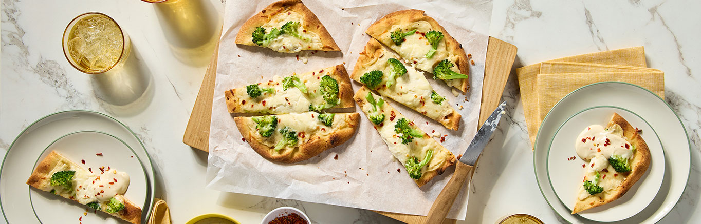 An image of prepared Lemon Ricotta Flatbread made with naan, Prego® Lemon Alfredo Sauce, ricotta cheese, broccoli florets and mozzarella cheese.