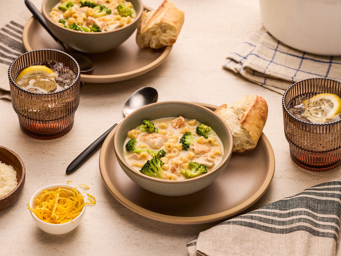 An image of prepared Chicken Alfredo Soup made with chicken, Swanson® 33% Less Sodium Chicken Broth, pasta, broccoli and Prego® Homestyle Alfredo Sauce.