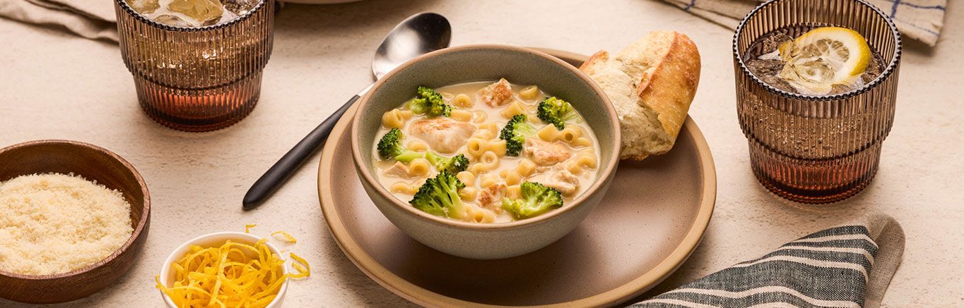 An image of prepared Chicken Alfredo Soup made with chicken, Swanson® 33% Less Sodium Chicken Broth, pasta, broccoli and Prego® Homestyle Alfredo Sauce.