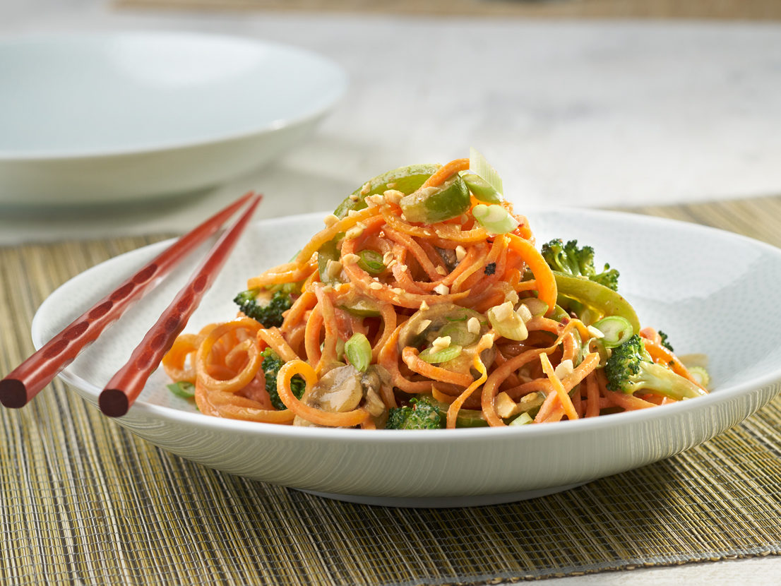 An image of the prepared Carrot Noodles with Spicy Thai Peanut Sauce made with mushrooms, green pepper, broccoli, Swanson® Chicken Broth, peanut butter and carrots.