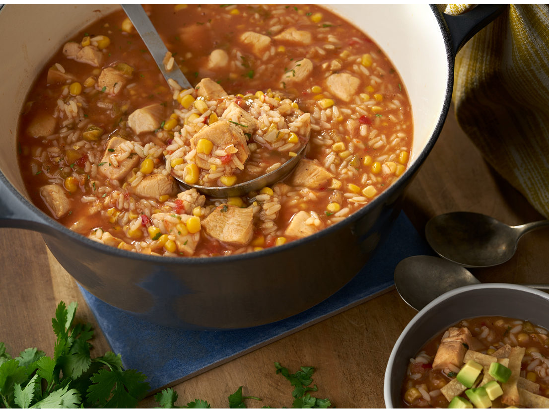 An image of prepared Hearty Chicken Tortilla Soup made with corn tortillas, chicken, Swanson® Chicken Broth, long grain white rice, corn, Pace® Chunky Salsa, lime juice and cilantro.