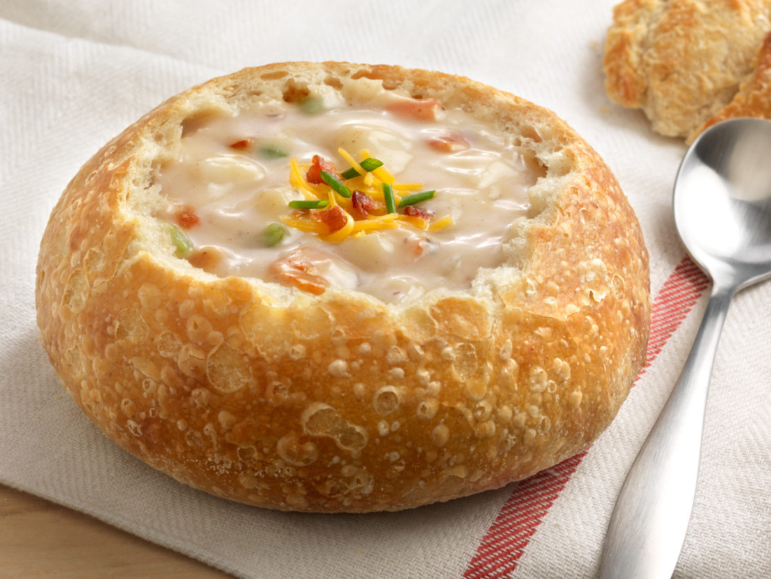 An image of prepared Loaded Potato Soup made with bacon, russet potatoes, onion, garlic, Swanson® Chicken Broth and green onion or chives.