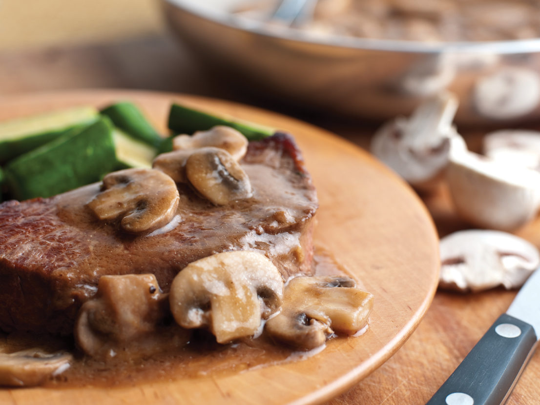 An image of prepared Pan-Seared Steaks with Mushroom Gravy made with steak, mushrooms and Swanson® Beef Broth or Beef Stock.