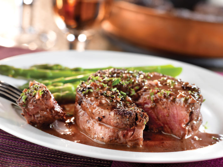An image of prepared Peppercorn-Seasoned Steaks with Mustard-Wine Sauce made with steak, pepper blend, Swanson® Beef Stock, wine and parsley.