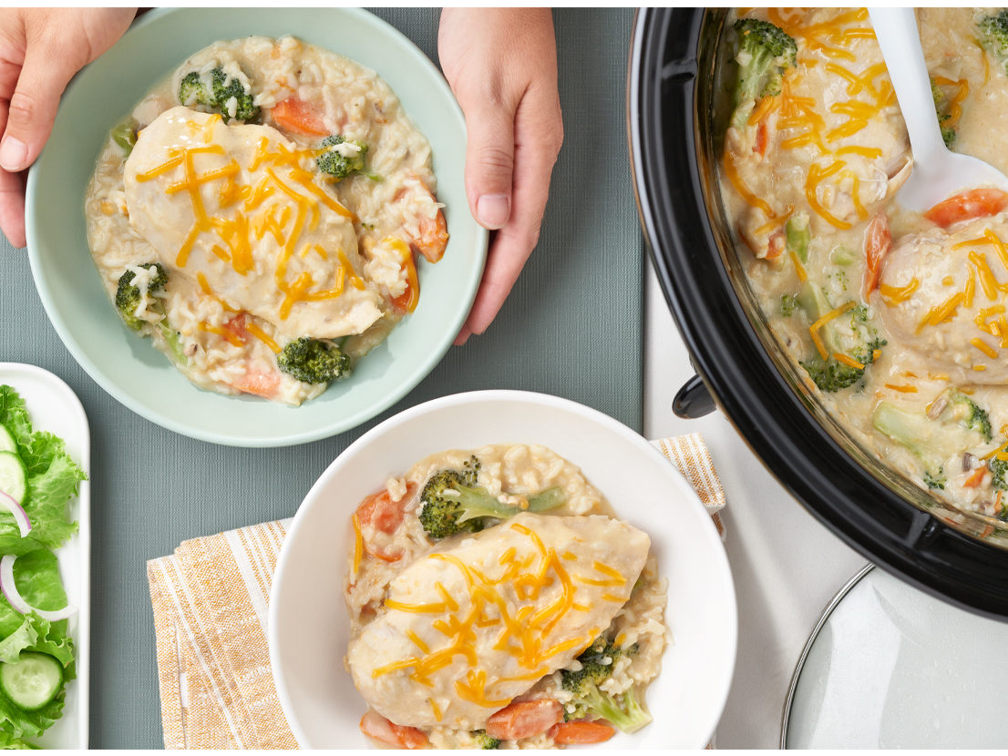 An image of prepared Slow Cooker Chicken, Broccoli & Rice made with Cheddar cheese, Campbell's® Condensed Cream of Chicken and Mushroom Soup, Campbell's® Condensed Cream of Chicken Soup, Swanson® Chicken Broth, broccoli, carrots, chicken and instant white rice.