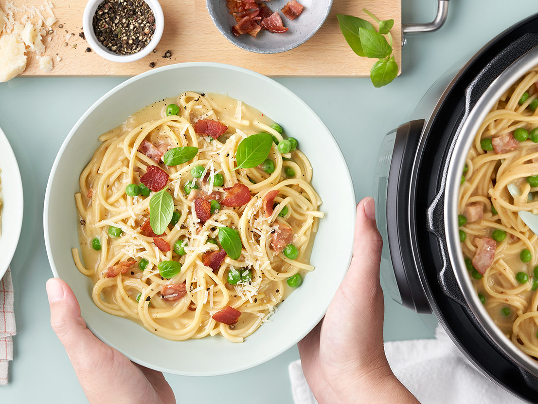 An image of prepared Instant Pot​​® Spaghetti Carbonara made with bacon, shallot, Swanson® Natural Goodness® Chicken Broth, Campbell's® Condensed Cream of Chicken Soup, spaghetti, Parmesan and green peas.