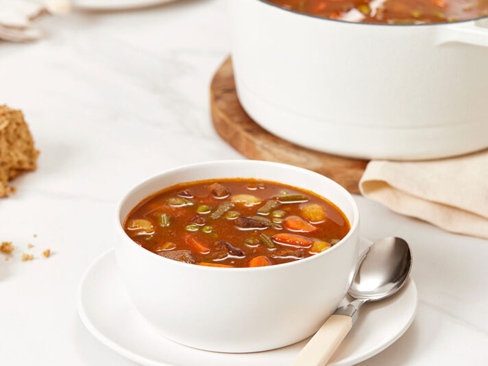 An image of prepared Beef & Vegetable Soup made with beef chuck roast, Yukon Gold potatoes, carrots, Swanson® Unsalted Beef Broth, green beans and peas.