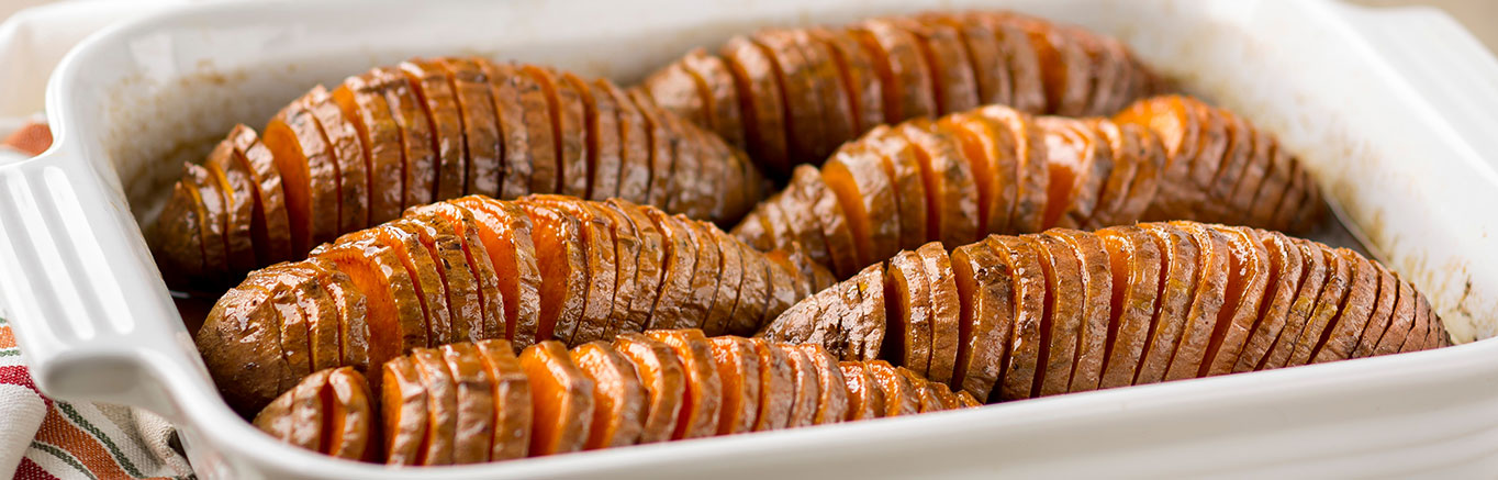An image of prepared Bourbon Pecan Hasselback Sweet Potatoes made with sweet potatoes, Swanson® Chicken Broth, bourbon, brown sugar and pecans.