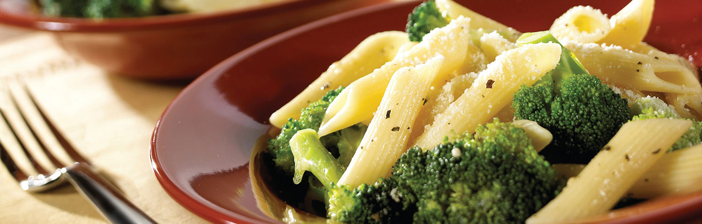 An image of prepared Broccoli & Garlic Penne Pasta made with Swanson® Chicken Broth, broccoli, penne pasta and Parmesan cheese.