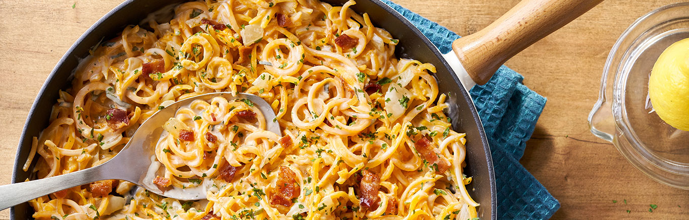 An image of prepared Butternut Squash Carbonara made with butternut squash noodles, onion, Prego® Roasted Garlic Parmesan Alfredo Sauce, Swanson® Vegetable Broth, sage, lemon, bacon and parsley.