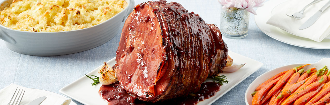 An image of prepared Cherry & Port Glazed Ham made with Swanson® Chicken Stock, port wine, dried cherries, and bone-in spiral sliced ham.