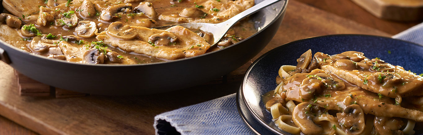 An image of prepared Chicken Marsala made with chicken breast, shallots, mushrooms, Marsala wine, Swanson® Chicken Broth, parsley and fettuccine pasta.