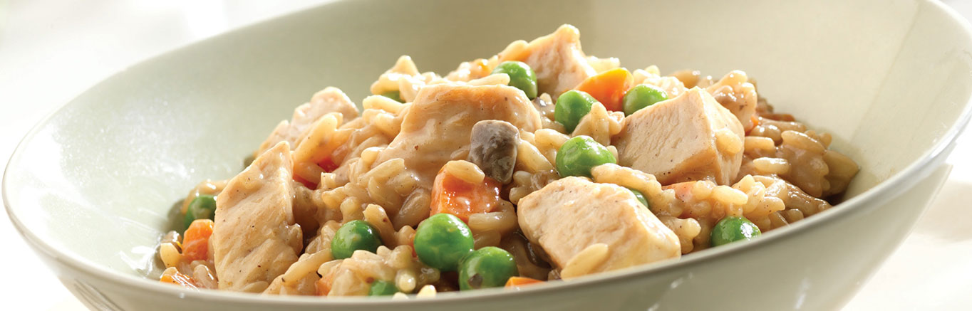 An image of prepared Chicken Mushroom Risotto made with chicken breast halves, onion, carrot, long grain white rice, Campbell's® Condensed Cream of Mushroom Soup, Swanson® Chicken Broth and peas.