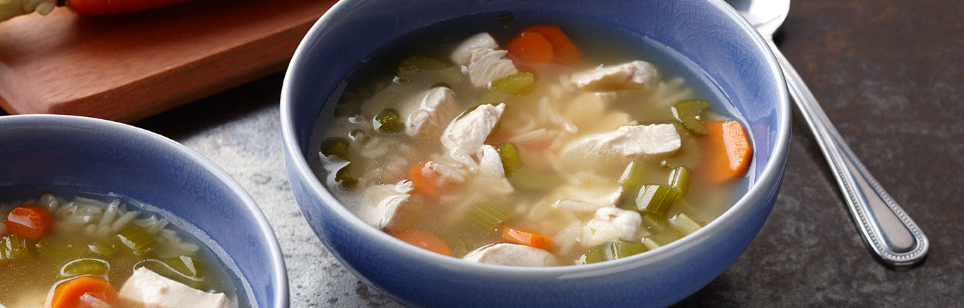 An image of prepared Chicken Rice Soup made with Swanson® Chicken Broth, carrot, celery, long grain white rice and chicken or turkey.