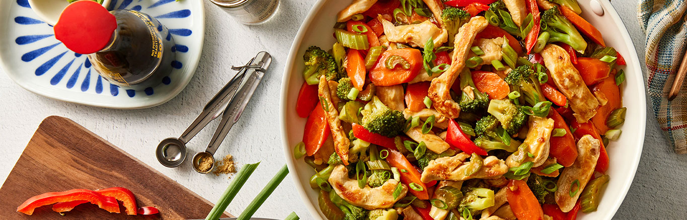 An image of prepared Chicken & Vegetable Stir-Fry made with Swanson® Chicken Broth, chicken, vegetables and white rice.