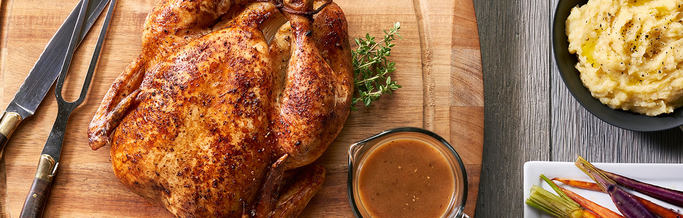 An image of prepared Classic Roasted Chicken with Pan Gravy made with a whole chicken, thyme and Swanson® Chicken Bone Broth.