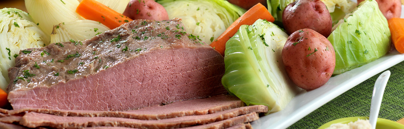 An image of prepared Corned Beef and Cabbage made with beef brisket, beer, Swanson® 50% Less Sodium Beef Broth, onion, potato, carrot and green cabbage.
