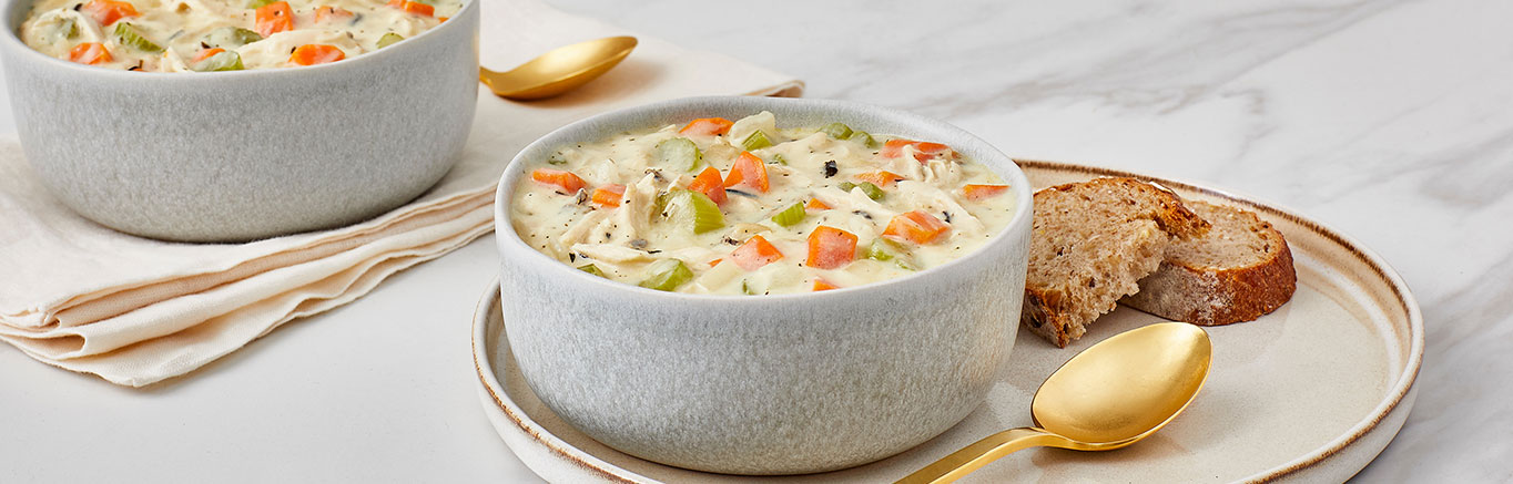 An image of prepared Creamy Chicken & Wild Rice Soup made with carrots, onion, celery, Swanson® Chicken Broth, chicken or turkey and seasoned long-grain and wild rice.