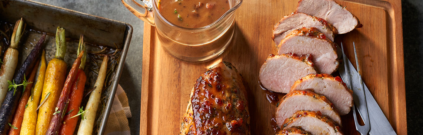 An image of prepared Dijon-Herb Pork Roast made with pork tenderloin, parsley, rosemary, thyme, red currant jelly, Dijon and Swanson® Chicken Stock.