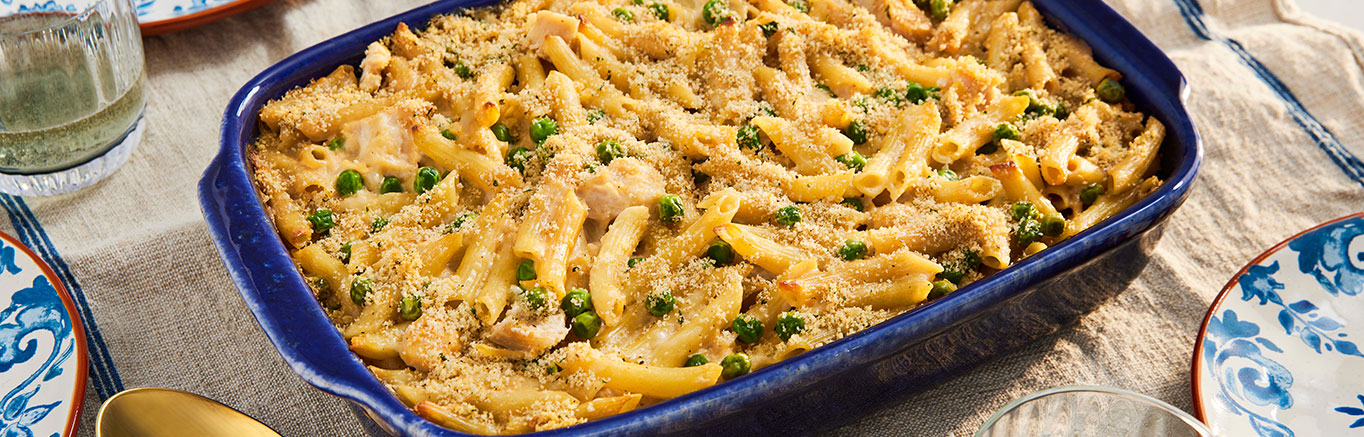 An image of prepared Easy Chicken Alfredo Bake made with penne pasta, Prego® Homestyle Alfredo Sauce, Swanson® Premium White Chicken Breast, peas and mozzarella cheese.