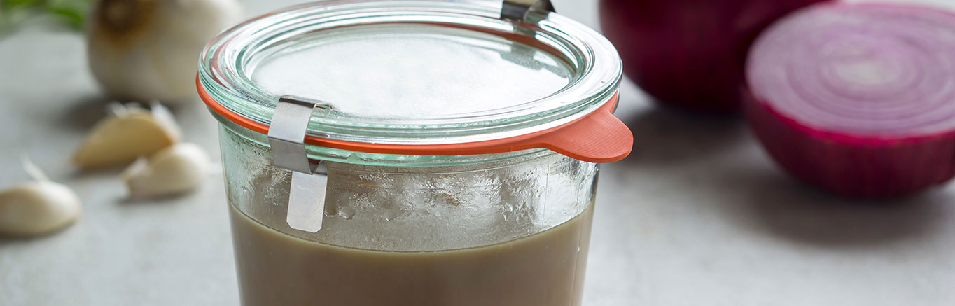 An image of the prepared Easy Make Ahead Turkey Gravy with Onions & Sage made with onion, garlic, flour, sage leaves, brandy, Swanson® Chicken Stock and turkey pan drippings.