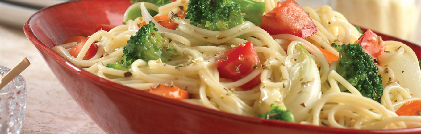 An image of prepared Easy Pasta Primavera made with Swanson® Natural Goodness® Chicken Broth, broccoli, carrot, onion, tomato, thin spaghetti and Parmesan cheese.