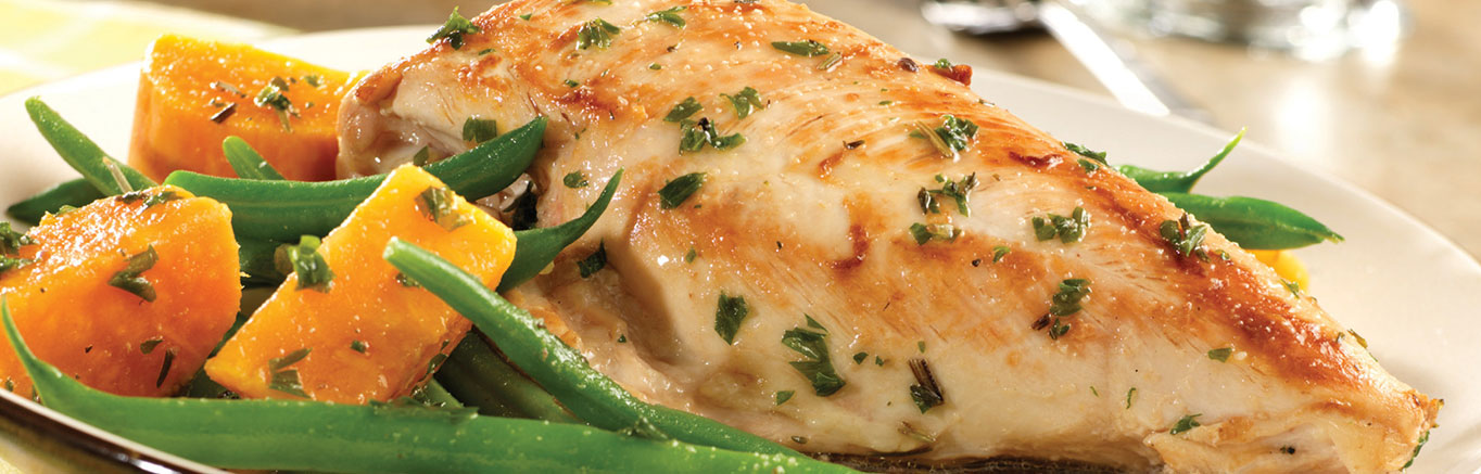 An image of prepared Golden Chicken & Autumn Vegetables made with chicken, Swanson® Natural Goodness® Chicken Broth, garlic, rosemary, thyme, sweet potato and green beans.