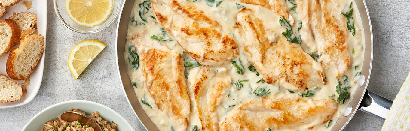 An image of prepared Healthy Lemon Chicken Scallopini with Spinach made with lemon, chicken breast, garlic, Swanson® Unsalted Chicken Stock, Campbell's® Healthy Request® Condensed Cream of Celery Soup and baby spinach.