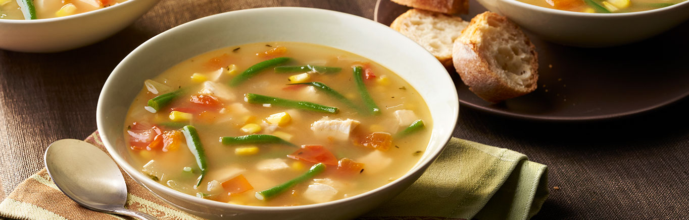 An image of prepared Hearty Chicken Vegetable Soup made with onion, Swanson® Chicken Broth, corn, green beans, tomato and chicken.