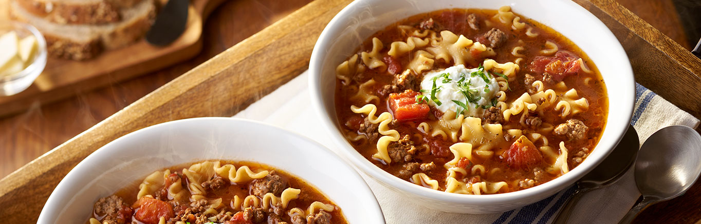 An image of Hearty Lasagna Soup made with ground beef, onion, Swanson® Beef Broth, tomatoes, mini lasagna noodles and Parmesan cheese.