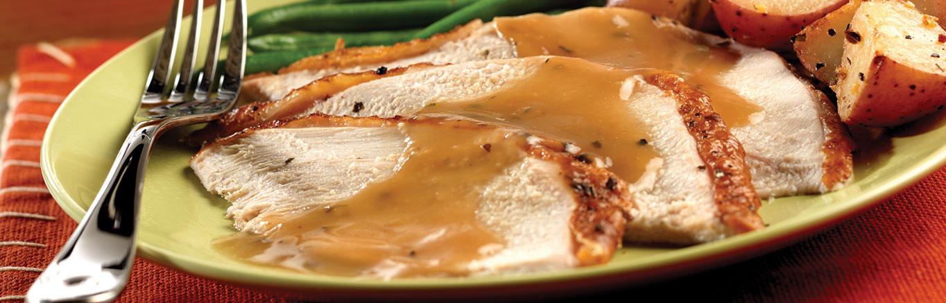 Image of prepared Herb Roasted Turkey made with Swanson® Chicken Stock, lemon, basil, thyme, turkey and Campbell's® Turkey Gravy.