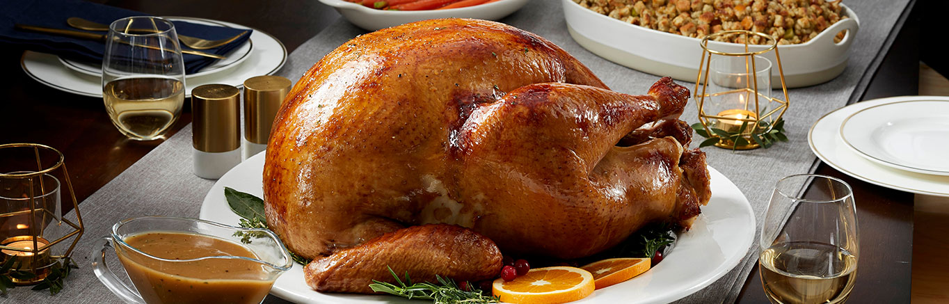 An image of prepared Herb Roasted Turkey with Pan Gravy made with turkey, Swanson® Chicken Stock, lemon juice, basil and thyme.