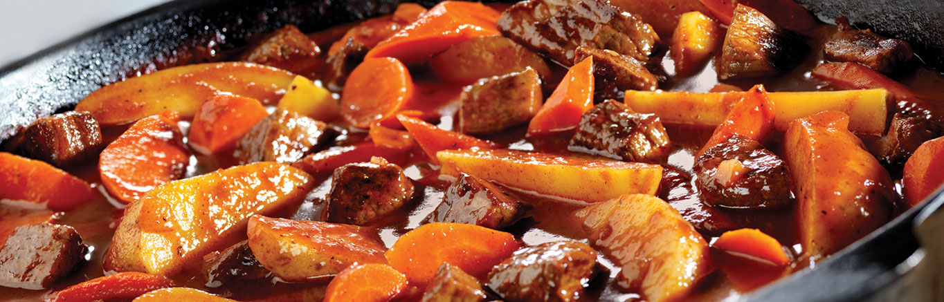 An image of prepared Homestyle Beef Stew for a Crowd made with beef, Campbell's® Tomato Juice, Swanson® Beef Broth, onion, carrots and potatoes.