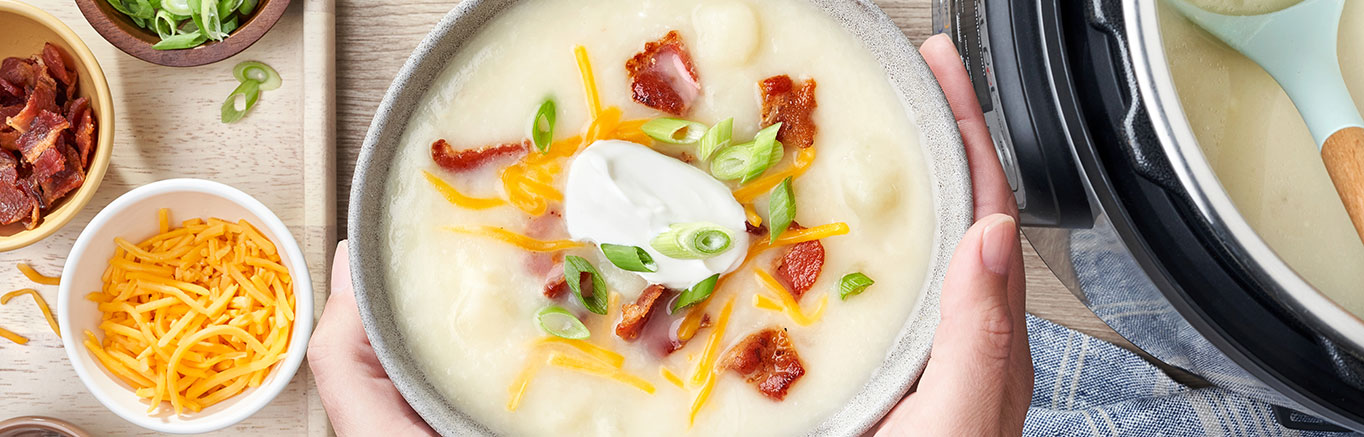 An image of prepared Instant Pot​® Potato Soup made with bacon, onion, russet potatoes, Swanson® Chicken Broth, Cheddar cheese and sour cream.