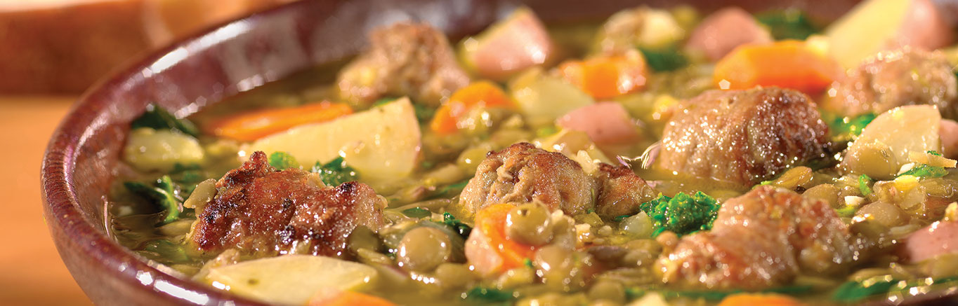 An image of Italian Sausage & Lentil Stew made with sweet Italian pork sausage, Swanson® Vegetable Broth, red potatoes, lentils and broccoli rabe.