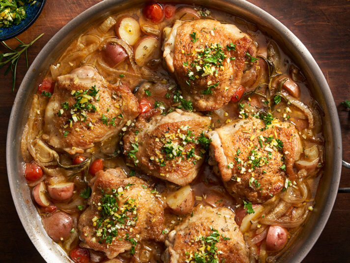 Image of prepared Lemon Rosemary Chicken made with chicken thighs, onions, fennel, grape tomatoes, baby red potatoes, Swanson® Chicken Bone Broth, rosemary and lemon.