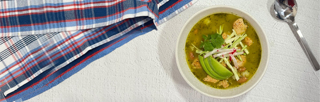 An image of prepared Chicken Pozole Soup made with chicken, garlic, Swanson® Chicken Broth, green chiles, cumin, cilantro, white hominy, pinto beans, cabbage and radishes.