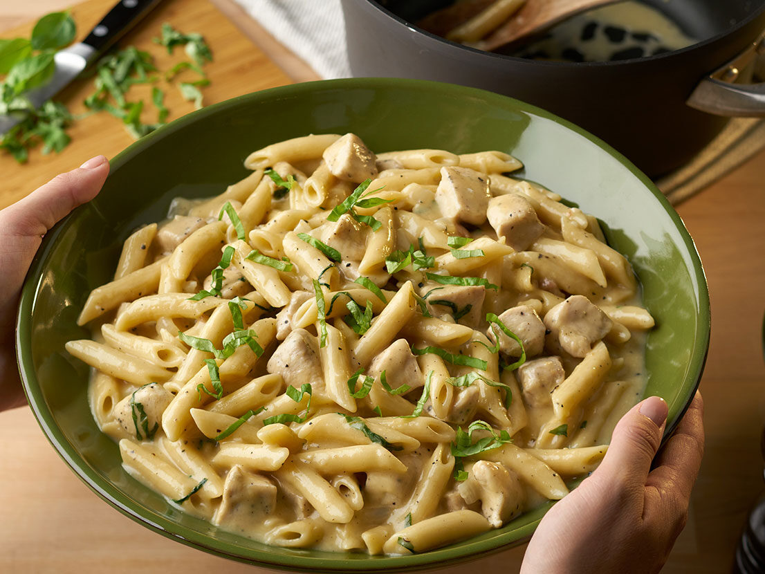 An image of prepared One Pot Chicken Parmesan Peppercorn Pasta made with chicken, Campbell's® Condensed Cream of Chicken Soup, Swanson® Chicken Broth, penne pasta, Parmesan cheese and basil.