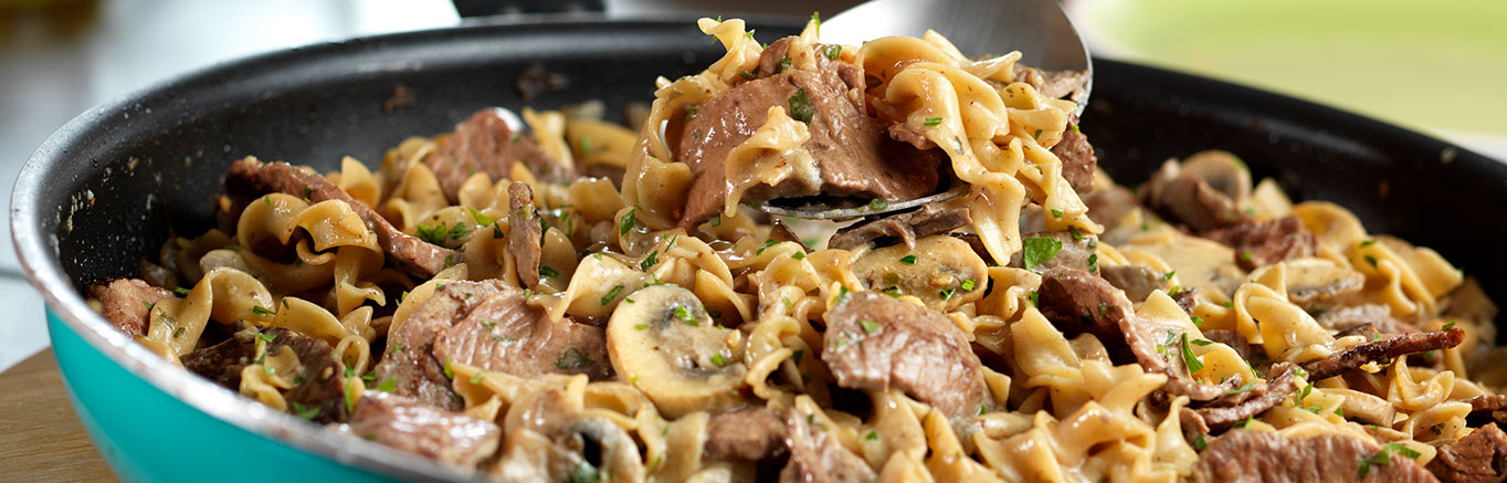 An image of prepared One-Dish Beef Stroganoff made with sirloin steak, onion, Swanson® Beef Broth or Beef Stock, mushrooms, egg noodles and sour cream.