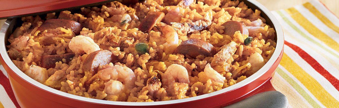 An image of prepared Pre-Game Paella made with white rice, Swanson® Chicken Broth, Pace® Picante Sauce, turmeric, turkey kielbasa, shrimp and chicken.
