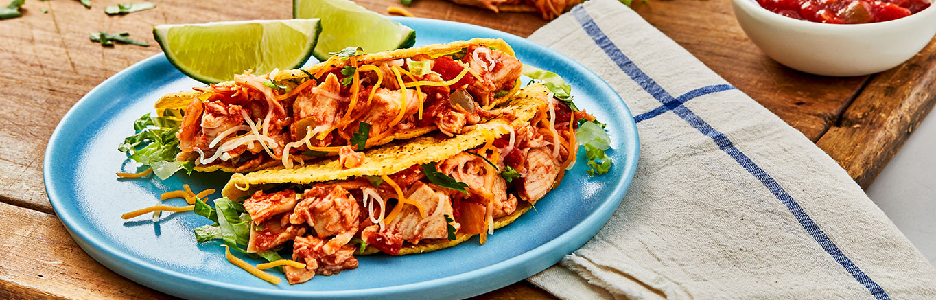 An image of prepared Quick Chicken Tacos made with Swanson® Premium White Chunk Chicken, Pace® Chunky Salsa, lettuce and Cheddar cheese.