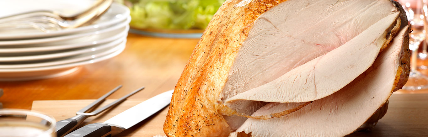 An image of prepared Roasted Turkey Breast with Herbed au Jus made with Swanson® Chicken Stock, bone-in turkey breast and Campbell's® Turkey Gravy.