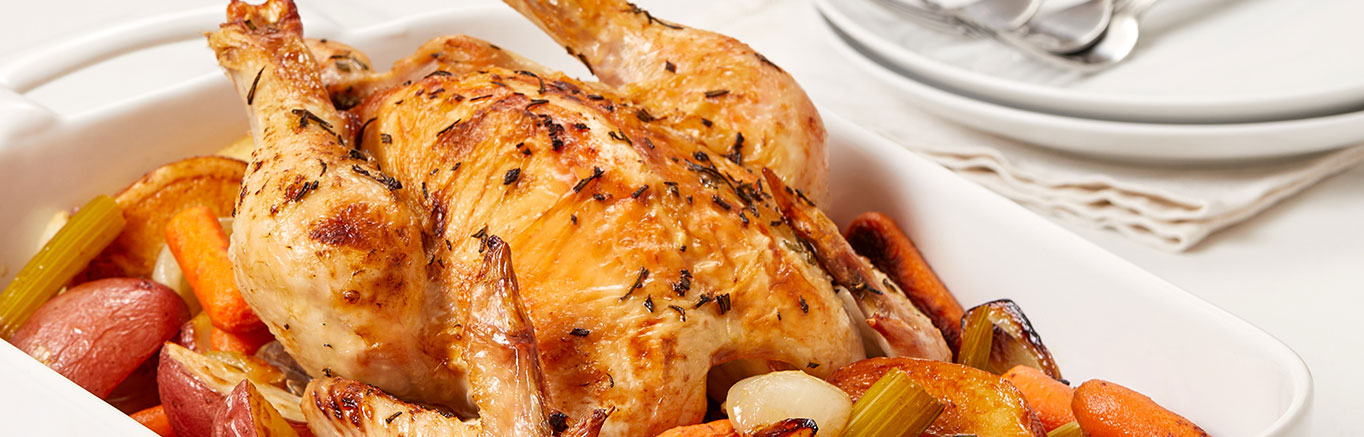 An image of prepared Rosemary Chicken & Roasted Vegetables made with chicken, red potatoes, baby carrots, celery, onion, rosemary, Swanson® Chicken Stock and orange juice.