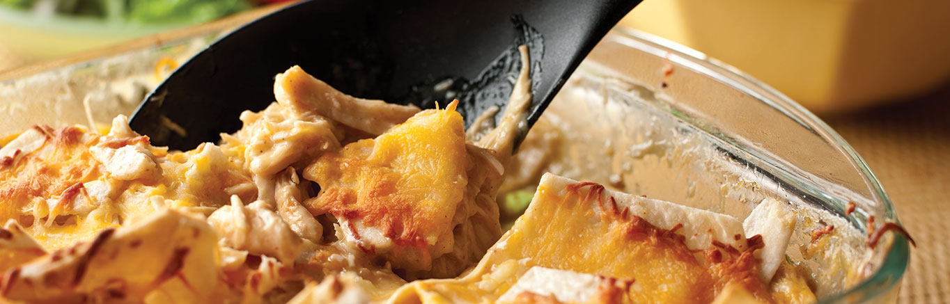 An image of prepared Slow Cooker Cheesy Chicken & Tortillas made with chicken, Swanson® Natural Goodness® Chicken Broth, Campbell's® Condensed Cream of Chicken Soup, flour tortillas, Mexican blend cheese and white rice.