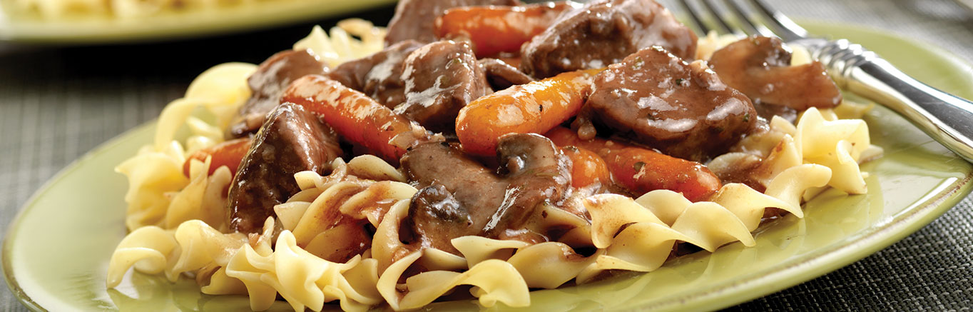 An image of prepared Savory Beef & Portobello Mushrooms made with sirloin steak, baby portobello mushrooms, garlic, Swanson® Beef Broth, wine, carrots and egg noodles.