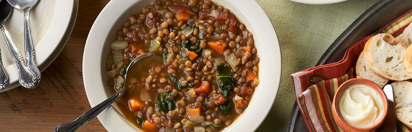 An image of prepared Savory Lentil Soup made with fennel, onion, carrot, celery, canned diced tomatoes, Swanson® Vegetable Broth, lentils, kale or spinach and Parmesan cheese.