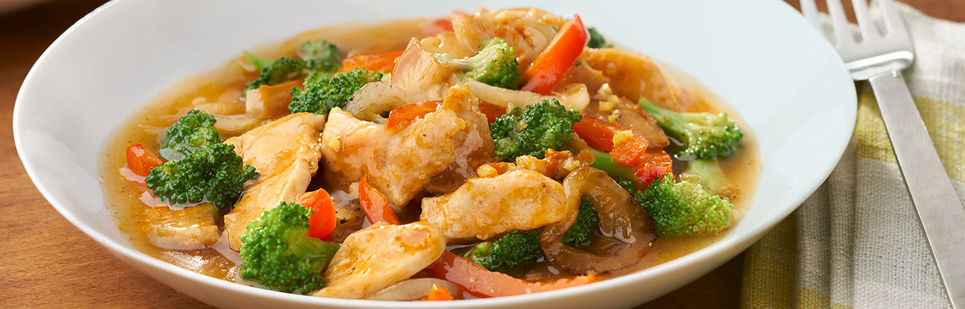 An image of prepared Sesame Sriracha Chicken Stir-Fry made with Swanson® Chicken Broth, chicken, ginger, garlic, broccoli, red bell pepper and onion.