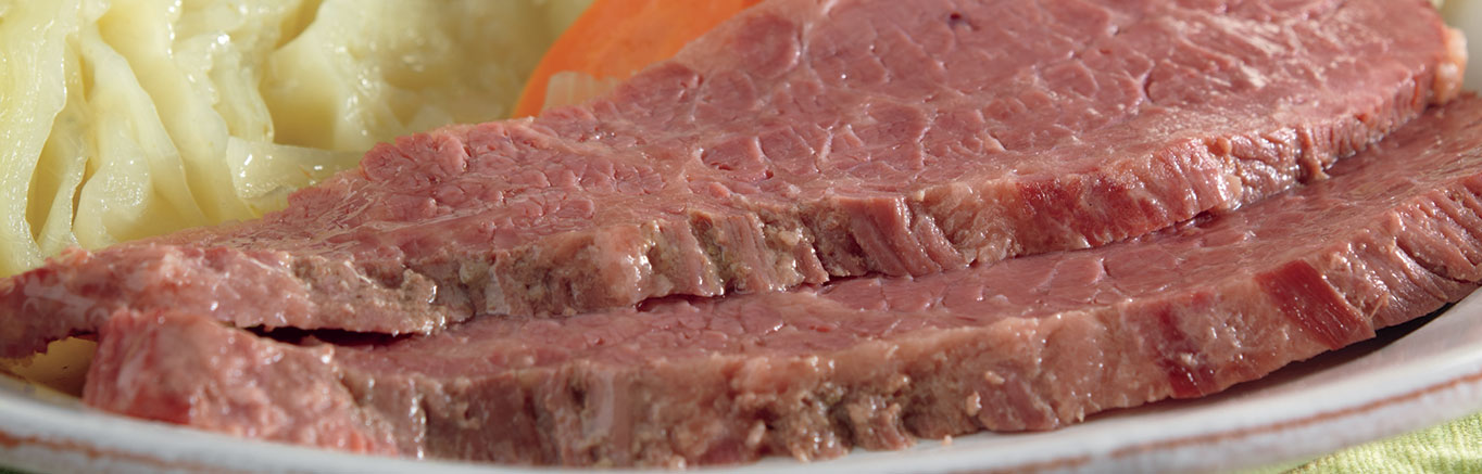 An image of prepared Slow Cooked Corned Beef & Cabbage made with Swanson® Beef Broth, onion, potatoes, carrots, beef brisket and green cabbage.