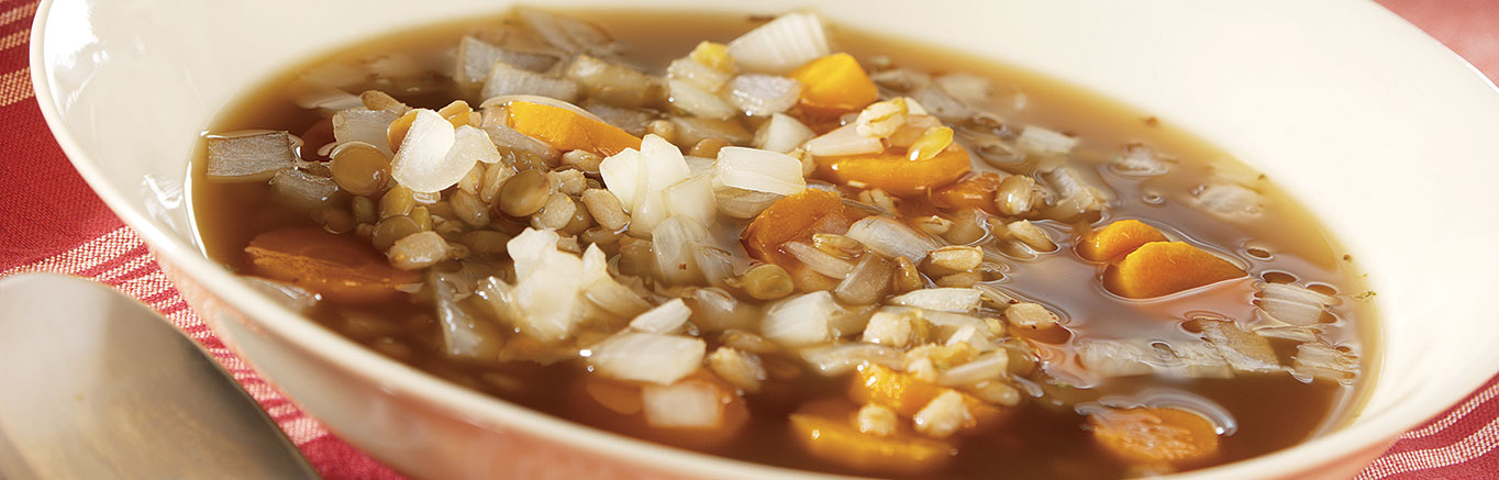 An image of prepared Slow Cooker Barley & Lentil Soup made with Swanson® Beef Broth, garlic, carrots, onion, lentils and barley.